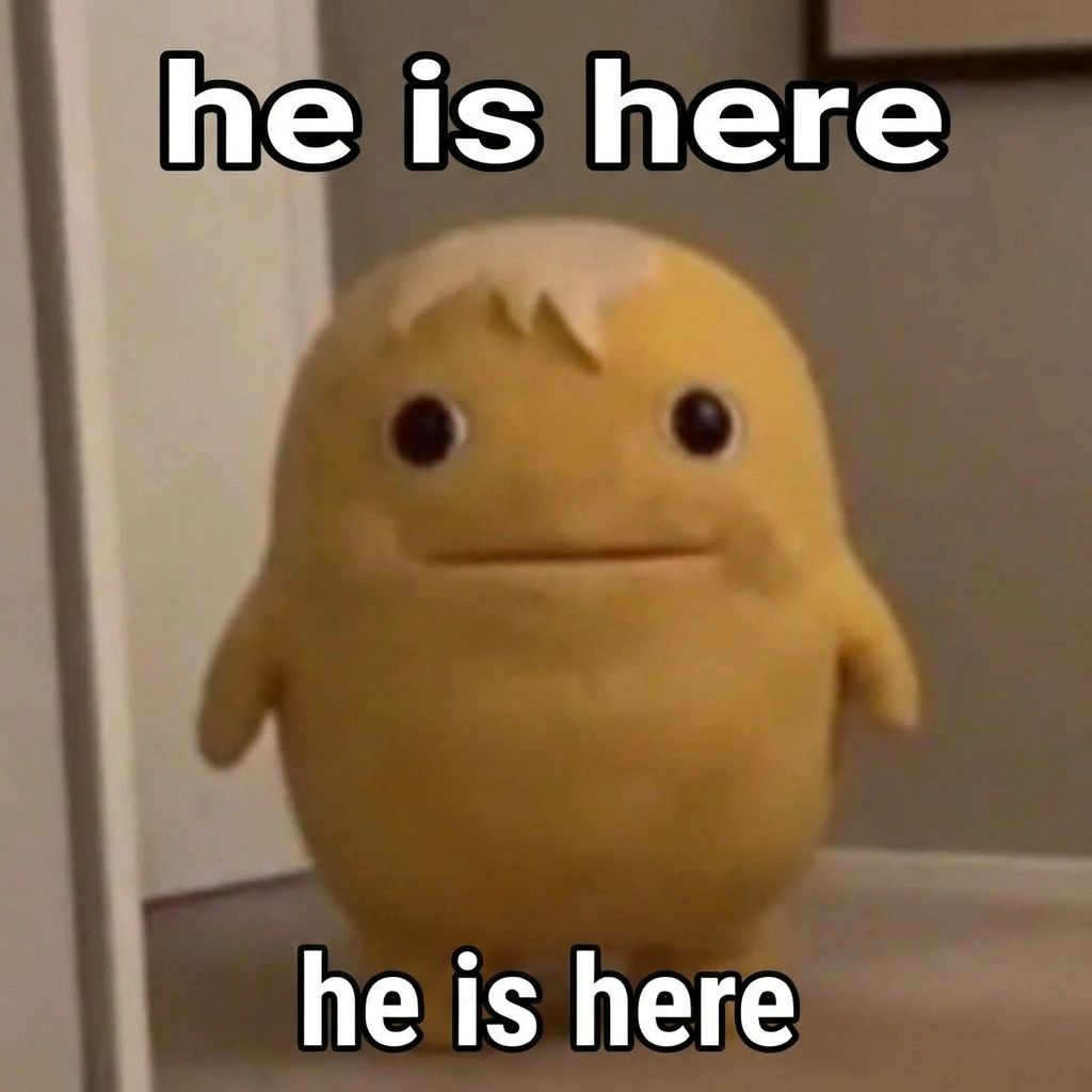 A small, round yellow plush creature with tiny stub arms, beady dark eyes, a tuft of hair on top, and a flat expressionless mouth, standing in a doorway and staring directly at the camera. White outlined text at the top and bottom both read "he is here."